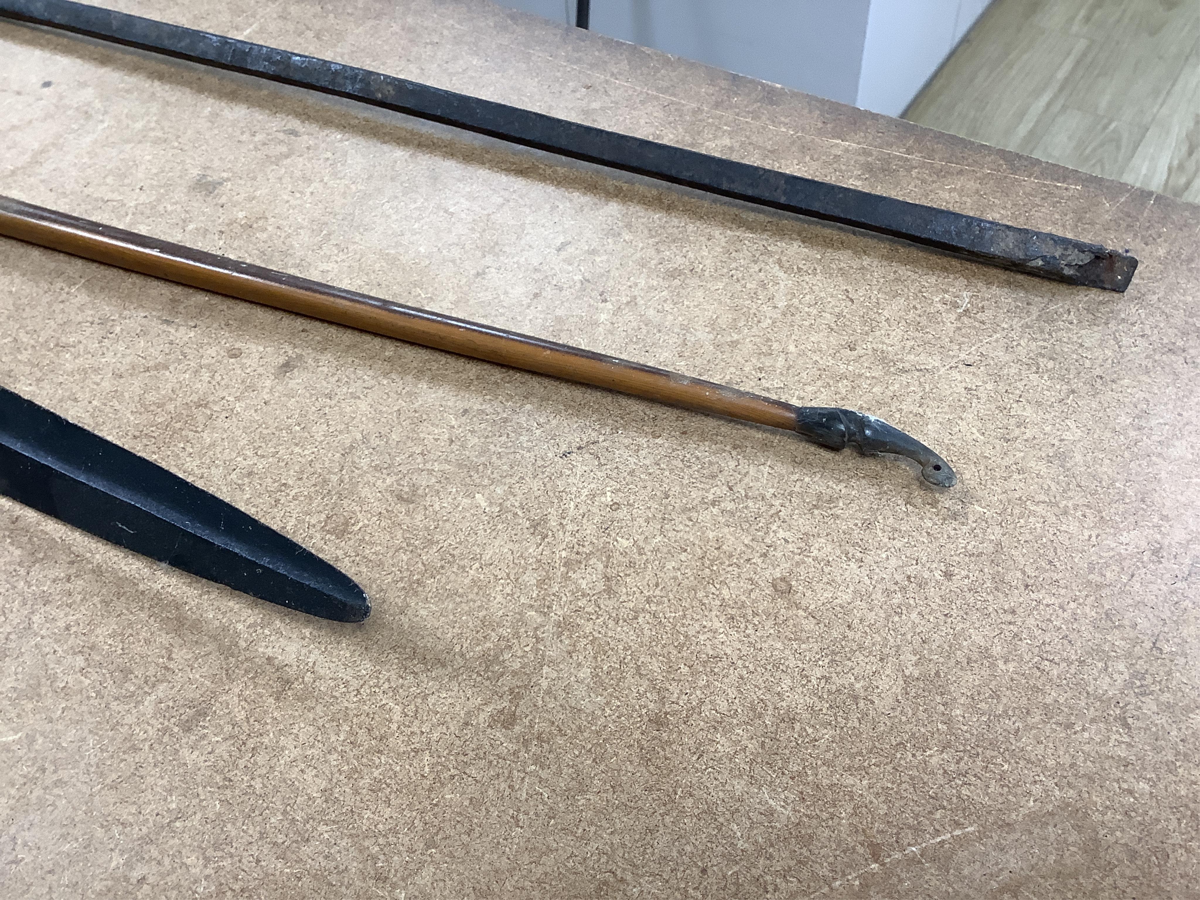 A collection of tribal spears, a fish hook, a cased snooker cue, etc.